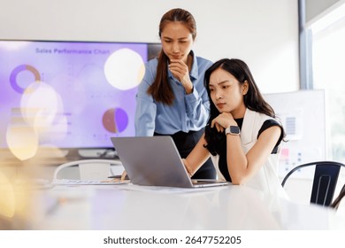  Two business woman lawyer or company employee holding accounting bookkeeping documents checking financial data or marketing report working in office with laptop. Paperwork management
