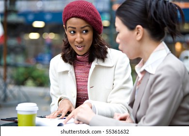 Two Business Women Having A Casual Meeting Or Discussion In The City. Shallow Depth Of Field.