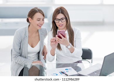 Two Business Women Looking At The Smartphone Screen