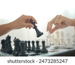 Two business women play chess and move chess pieces. Business management competition and leadership concepts.