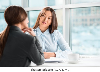 Two Business Women Talking And Signing Contract At Office