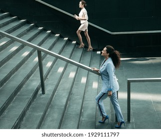 Two Business Women Walking Up On Stairs