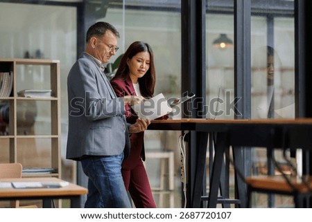 Two business working together using digital tablet pc and talking about a business project. Small creative diversity team of females executives meeting work in office.
