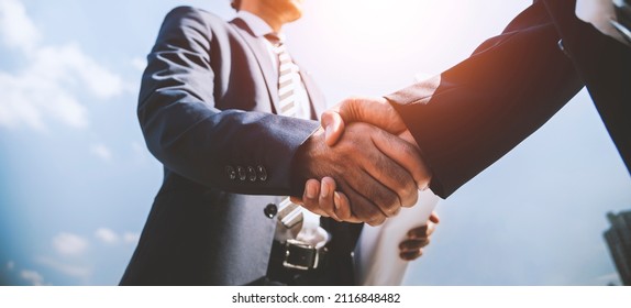 Two businessman engineer developer shaking hands with business deals and congratulations on success.