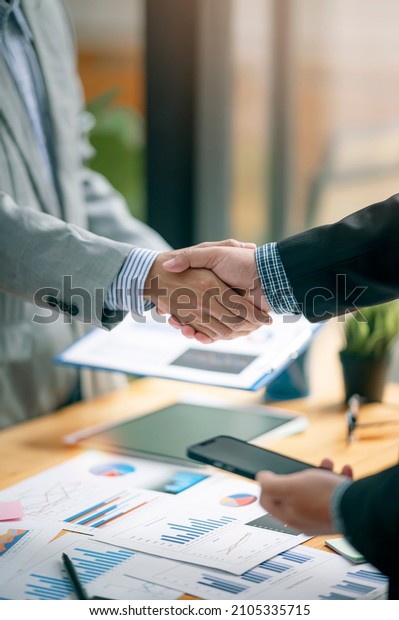 Two Businessman handshake for\
teamwork of business merger and acquisition at\
office.