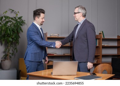 Two businessman are happy because of successful completed deal - Shutterstock ID 2235694855