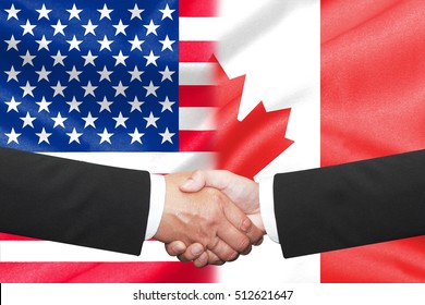 Two Businessman Having A Handshake Over Us And Canada Flag