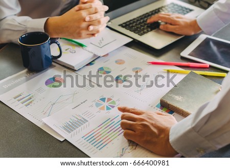 Two businessman investment consultant analyzing company financial report balance sheet statement working with documents graphs. Concept picture for stock market, office, tax,and project.