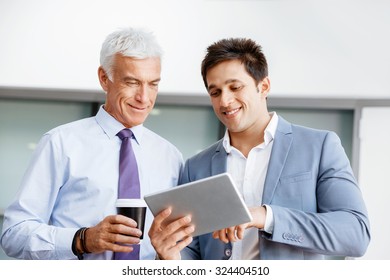 Two businessman in office with devices - Shutterstock ID 324404510