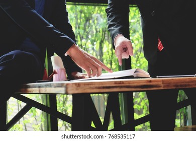 Two Businessman Working Together About Documents, Partner Discuss Plan Or Idea And Opinion Meeting, Asian Bussiness Are Discussing Their Working On  Wood Table Beside Window At Coffee Shop 