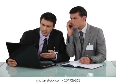 Two Businessmen Arguing At A Desk