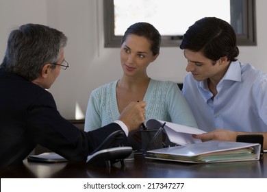 Two businessmen with a businesswoman discussing in a meeting