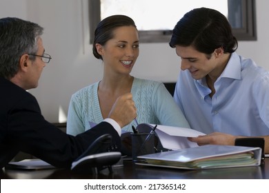 Two businessmen with a businesswoman discussing in a meeting