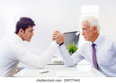 Two businessmen competing arm wrestling in office