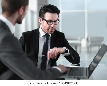 two businessmen discussing information from a laptop. - Shutterstock ID 1304282221