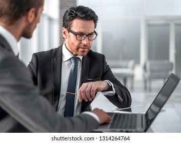 two businessmen discussing information from a laptop. - Shutterstock ID 1314264764
