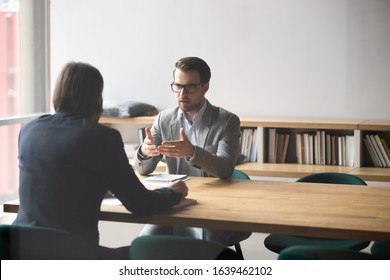 Two Businessmen Having Conversation, Sitting At Table In Boardroom, Discussing Strategy, Ideas During Negotiation, Serious Hr Manager Wearing Glasses Holding Job Interview With Applicant