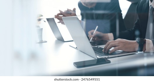 Two businessmen having a discussion, working on laptop computer, using digital tablet and mobile phone during meeting at office. Business planning and solution, working together concept - Powered by Shutterstock