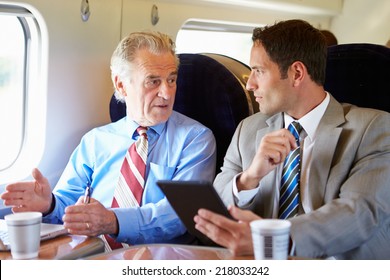 Two Businessmen Having Meeting On Train