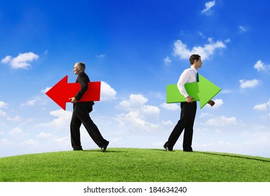 Two Businessmen Holding Contrasting Arrows Going Seperate Ways