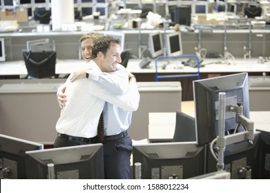 Two Businessmen Hugging In Office