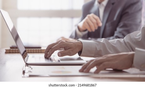 Two businessmen with laptop computer reviewing financial statements for a business performance, investment risk analysis and return on investment, ROI. 