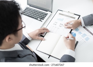 Two businessmen looking at report and having a discussion in office. - Shutterstock ID 271607267