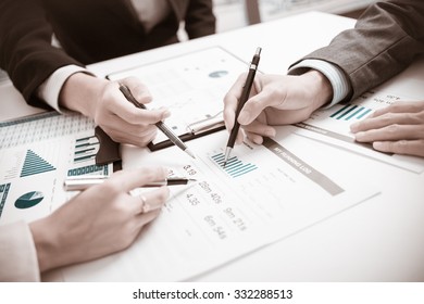 Two businessmen looking at report and having a discussion in office. - Shutterstock ID 332288513