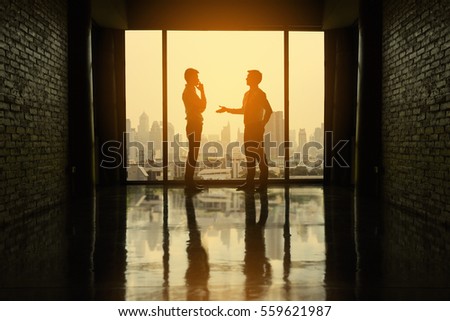 Two businessmen are negotiating business in office on the building.
Two businessmen business negotiations.(Silhouette)
