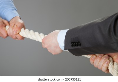 Two businessmen pulling a rope, closeup shot