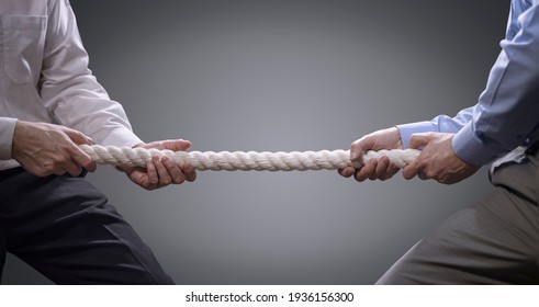 Two businessmen pulling tug of war with a rope concept for business competition, rivalry, challenge or dispute