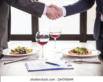 Two Businessmen Shaking Hands During A Business Lunch. Business Meeting.