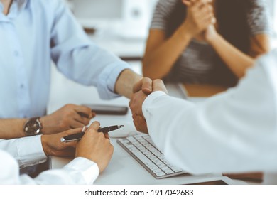 Two businessmen are shaking hands in office while sitting at the desk, close-up. Colleagues applauding of success meeting end. Business people concept - Shutterstock ID 1917042683