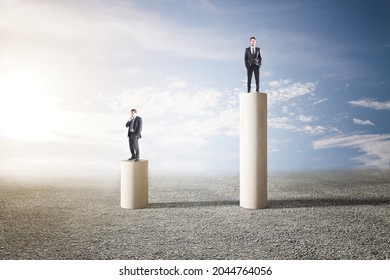 Two Businessmen Standing On Abstract Pillars On Sky Background. Teamwork, Worker And CEO Concept