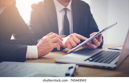 Two Businessmen Using Touchpad At Meeting