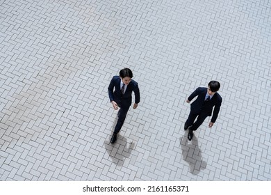 Two Businessmen Walking In The Office District