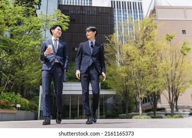 Two Businessmen Walking In The Office District