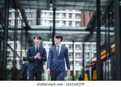 Two Businessmen Walking In The Office District