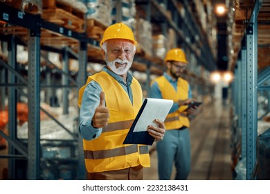 Two businessmen in warehouse. Selective focus on senior man with helmet in warehouse. - Powered by Shutterstock