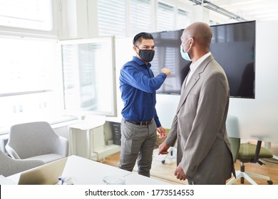 Two businessmen wearing a mask for Covid-19 and corona virus are discussing a project in the office - Powered by Shutterstock