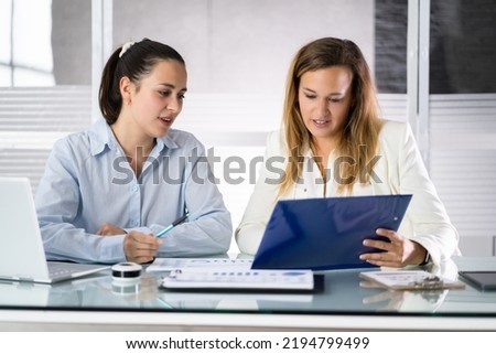 Two Businesspeople Analyzing Financial Graph And Data