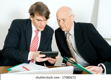 Two Businesspeople Crunching The Numbers