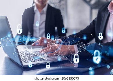 Two businesspeople in formal wear working on the project to protect cyber security of international company using laptop. Padlock Hologram icons. Teamwork concept.