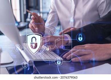 Two businesspeople in formal wear working on the project to protect cyber security of international company using laptop. Padlock Hologram icons. Teamwork concept. - Shutterstock ID 2076379063