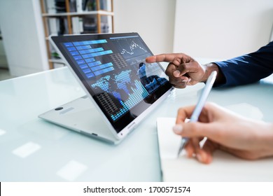 Two Businesspeople Working Together With Financial Graph On Laptop - Powered by Shutterstock