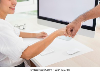 Two businesspersons fist-bumping in agreement at a meeting at office