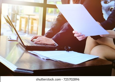 Two Businesswoman Working Together About Documents And Us Laptop , Partner Discuss Plan Or Idea And Opinion Meeting, Asian Bussiness Are Discussing Their Working Beside Window At Coffee Shop 