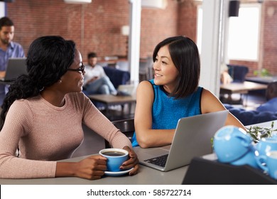 Two Businesswomen Have Informal Meeting In Office Coffee Bar