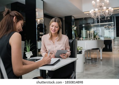 Two Businesswomen Having Meeting At Hotel Lobby.