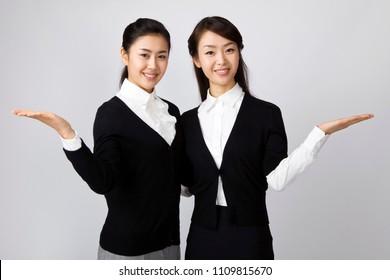 two businesswomen presenting something with hands